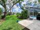 Lush backyard with mature trees and a screened pool area, ready for entertaining at 608 Apalachicola Rd, Venice, FL 34285