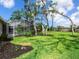 Scenic backyard with mature trees, a screened-in pool area, and lush landscaping at 608 Apalachicola Rd, Venice, FL 34285