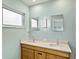 Bathroom featuring a double sink vanity with quartz countertop, modern lighting, and sleek mirrors at 608 Apalachicola Rd, Venice, FL 34285