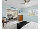 Bright bedroom boasts a sliding door to a screened-in lanai with outdoor seating and view of the backyard at 608 Apalachicola Rd, Venice, FL 34285