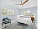 Bright bedroom with a modern ceiling fan, blue accent rug, and shuttered windows allowing natural light at 608 Apalachicola Rd, Venice, FL 34285