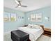 Bedroom with a modern ceiling fan, shuttered windows, a padded ottoman, and decorative pillows at 608 Apalachicola Rd, Venice, FL 34285
