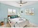 Bedroom with ceiling fan, bright shuttered windows, and stylish patterned bedding and throw pillows at 608 Apalachicola Rd, Venice, FL 34285