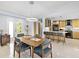 Dining area next to a modern kitchen and an entry door with multiple windows at 608 Apalachicola Rd, Venice, FL 34285
