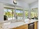 Kitchen with a large window with a view of the screened-in pool and outdoor area at 608 Apalachicola Rd, Venice, FL 34285