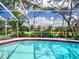 Sparkling pool with screened enclosure and serene garden views at 608 Apalachicola Rd, Venice, FL 34285