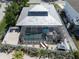 Stunning aerial view of the property with pool, stylish metal roof, and fenced yard at 616 Gardenia Dr, Venice, FL 34285
