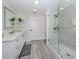 Modern bathroom with a double sink vanity, glass-enclosed shower, and stylish tile work, offering a sleek and functional space at 616 Gardenia Dr, Venice, FL 34285