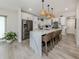 Bright kitchen features an island with seating, stainless steel appliances, white cabinets and hardwood floors at 616 Gardenia Dr, Venice, FL 34285