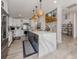 Bright kitchen features an island with seating, stainless steel appliances, white cabinets and hardwood floors at 616 Gardenia Dr, Venice, FL 34285
