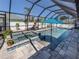Inviting screened-in pool and spa area surrounded by lush landscaping and comfortable seating, creating a private oasis at 616 Gardenia Dr, Venice, FL 34285