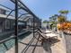 Relaxing screened pool area with lounge chairs, pavers, and tropical foliage at 616 Gardenia Dr, Venice, FL 34285