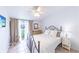 Bedroom with neutral walls, tiled floors, a ceiling fan and abundant natural light from a sliding glass door at 633 White Pine Tree Rd # 27, Venice, FL 34285