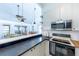 Open kitchen features white cabinets, stainless steel appliances, eat-in bar, and flows into adjacent living area at 633 White Pine Tree Rd # 27, Venice, FL 34285