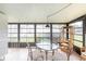 Sunroom featuring a glass table and multiple windows with views of the outdoors at 633 White Pine Tree Rd # 27, Venice, FL 34285