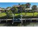 Waterfront backyard featuring a private dock with jet ski lift and lush tropical landscaping at 6724 Schooner Bay Cir # 6724, Sarasota, FL 34231