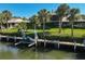 Waterfront backyard featuring a private dock with jet ski lift and lush tropical landscaping at 6724 Schooner Bay Cir # 6724, Sarasota, FL 34231