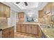 Well-appointed kitchen with granite counters, tile backsplash, natural wood cabinets, and tile flooring at 6724 Schooner Bay Cir # 6724, Sarasota, FL 34231