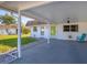 The home has a white exterior, covered parking spot with blue chair, and green lawn at 680 Circlewood Dr # W3, Venice, FL 34293