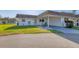 Cozy home with white exterior, front yard, and covered parking spot with blue chair at 680 Circlewood Dr # W3, Venice, FL 34293