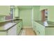 Vintage kitchen with green cabinets, tile floor, and a double sink at 680 Circlewood Dr # W3, Venice, FL 34293