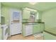 Cozy kitchen with bright green cabinets, white appliances, and access to backyard at 680 Circlewood Dr # W3, Venice, FL 34293