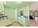 Vintage green kitchen featuring tile floors, neutral countertop, and a pass-through to living room at 680 Circlewood Dr # W3, Venice, FL 34293