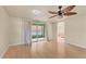 Spacious living room featuring ceiling fan, wood floors, and sliding glass doors to a screened in patio at 680 Circlewood Dr # W3, Venice, FL 34293