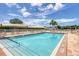 Community pool featuring clear blue water and lounge chairs, set against a bright blue sky with light clouds at 680 Circlewood Dr # W3, Venice, FL 34293