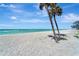 Beautiful beach view with palm trees and blue skies at 700 Golden Beach Blvd # 115, Venice, FL 34285