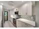 Modern kitchen boasts stainless appliances, sleek white cabinetry, and stylish backsplash at 700 Golden Beach Blvd # 115, Venice, FL 34285