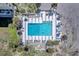 Overhead view of a bright blue pool with surrounding deck, lounge chairs, and palm trees at 700 Golden Beach Blvd # 115, Venice, FL 34285