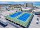 Elevated view of pristine blue tennis courts with the city and ocean in the background at 700 Golden Beach Blvd # 115, Venice, FL 34285