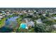 Aerial view featuring a community pool, tennis courts, and pond, surrounded by well-maintained homes and lush landscaping at 744 Fringed Orchid Trl, Venice, FL 34293