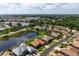 Overhead view of a single-story home near a lake, complete with a well-kept lawn at 744 Fringed Orchid Trl, Venice, FL 34293