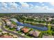 Aerial view of a single-story home near a lake within a gated community at 744 Fringed Orchid Trl, Venice, FL 34293