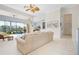 Open living room boasts sliding doors to screened patio and backyard water views at 744 Fringed Orchid Trl, Venice, FL 34293