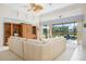 Bright living room with high ceilings and sliding doors to screened patio overlooking lush backyard and water at 744 Fringed Orchid Trl, Venice, FL 34293