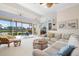 Open living room boasts sliding doors to screened patio and backyard water views at 744 Fringed Orchid Trl, Venice, FL 34293