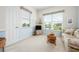 Sitting room with blue walls, a large window, and neutral carpeting at 744 Fringed Orchid Trl, Venice, FL 34293