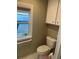 Bright bathroom with a toilet and window at 795 Cervina N Dr, Venice, FL 34285