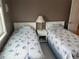 Cozy bedroom with two twin beds and a wicker nightstand at 795 Cervina N Dr, Venice, FL 34285