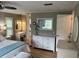 This is an airy primary bedroom with white dressers, smooth wood floors, and a bright ensuite at 795 Cervina N Dr, Venice, FL 34285