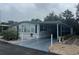 Charming mobile home featuring neutral tones, a screened porch, and a carport with decorative landscaping at 795 Cervina N Dr, Venice, FL 34285