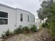Exterior side view of home showcasing landscaping and white picket fence at 795 Cervina N Dr, Venice, FL 34285