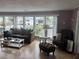 Bright living room with large windows, comfortable seating, and laminate wood floors at 795 Cervina N Dr, Venice, FL 34285