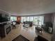 Inviting living room with fireplace, hardwood flooring, and numerous windows for natural light at 795 Cervina N Dr, Venice, FL 34285