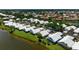 Aerial view of waterfront homes, showcasing lush landscaping and a tranquil pond for an appealing community setting at 799 Harrington Lake N Dr # 73, Venice, FL 34293