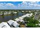 An aerial view of a lakeside home with white roof, lush landscaping, and serene water views at 799 Harrington Lake N Dr # 73, Venice, FL 34293