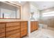 Bathroom featuring dual vanities, a large mirror, and tiled walk-in shower at 799 Harrington Lake N Dr # 73, Venice, FL 34293